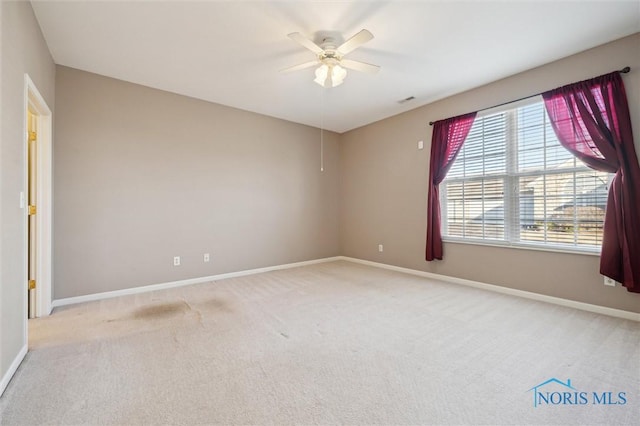 spare room featuring ceiling fan and light carpet