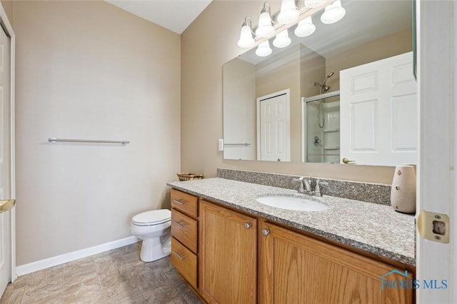 bathroom with vanity, toilet, a shower with shower door, and a notable chandelier