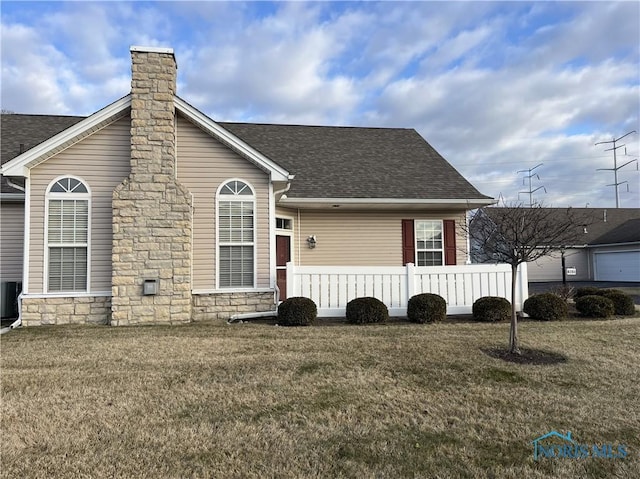 view of front of property featuring cooling unit and a front lawn