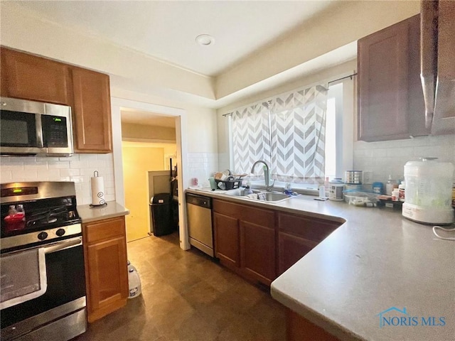 kitchen with appliances with stainless steel finishes, sink, and backsplash