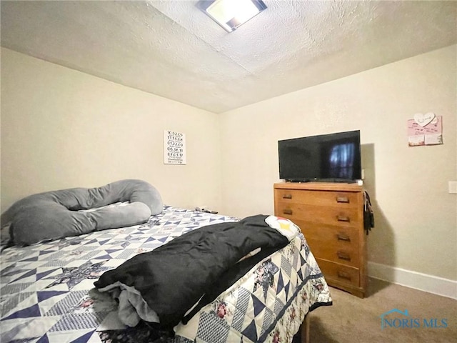 bedroom featuring carpet and a textured ceiling