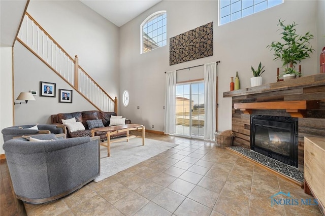 tiled living room with a high ceiling and a high end fireplace