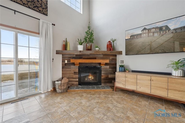 living room with a water view and a towering ceiling