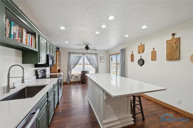 kitchen with sink, stainless steel range with electric stovetop, a center island, a textured ceiling, and dark hardwood / wood-style floors