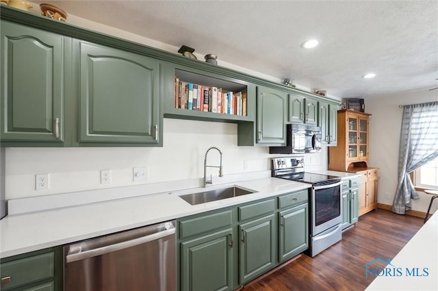 kitchen with sink, appliances with stainless steel finishes, a textured ceiling, green cabinetry, and dark hardwood / wood-style flooring