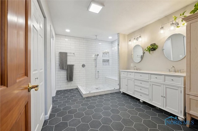 bathroom with tile patterned flooring, vanity, and tiled shower