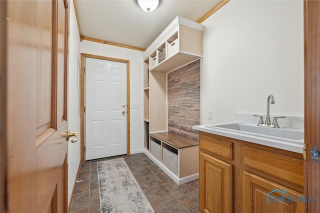 mudroom with crown molding and sink