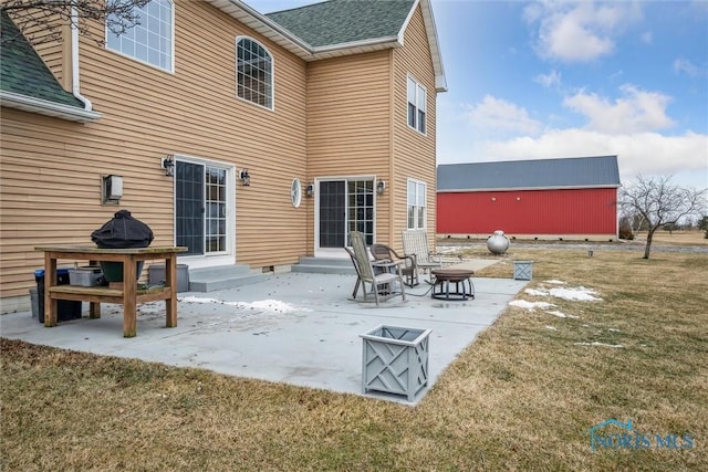 rear view of property featuring a patio area and a lawn