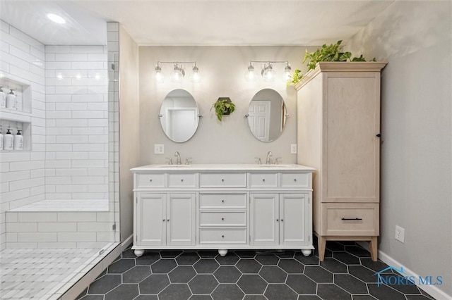 bathroom with tile patterned floors, vanity, and tiled shower