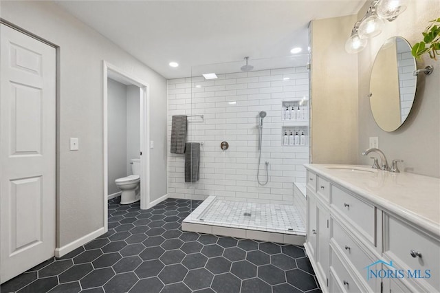 bathroom featuring vanity, tile patterned flooring, toilet, and walk in shower