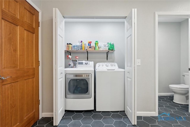 laundry area with washer and dryer and dark tile patterned floors