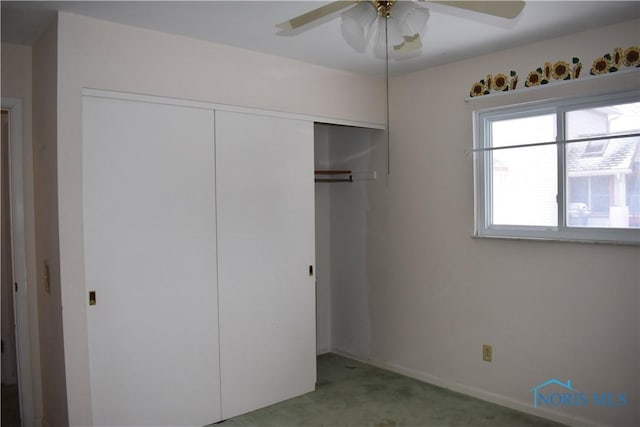 unfurnished bedroom featuring light colored carpet, a closet, and ceiling fan