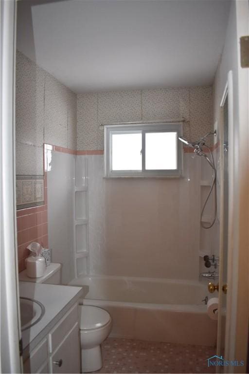 full bathroom featuring vanity, toilet, tile walls, and shower / tub combination