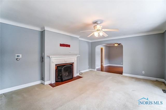 unfurnished living room featuring ceiling fan, carpet flooring, and a fireplace