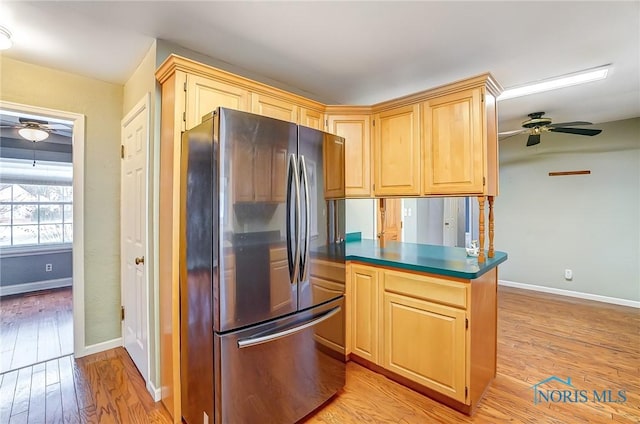 kitchen featuring light brown cabinetry, stainless steel refrigerator, ceiling fan, kitchen peninsula, and light hardwood / wood-style flooring