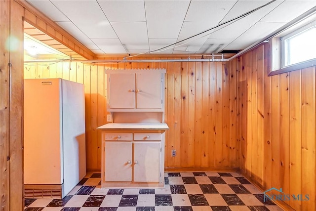 basement with wood walls and white fridge