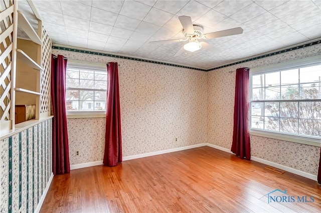 empty room featuring hardwood / wood-style flooring and ceiling fan