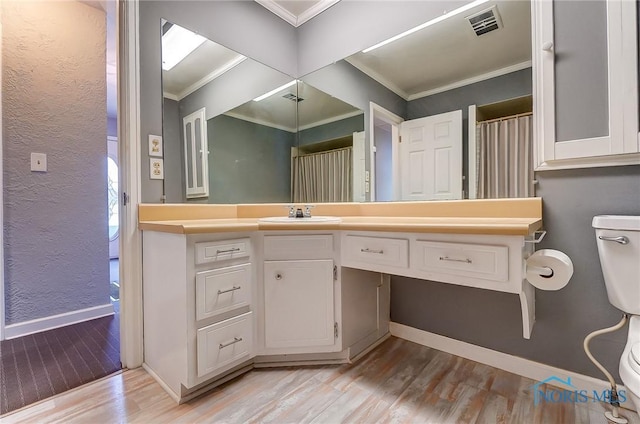 bathroom with vanity, hardwood / wood-style floors, and crown molding