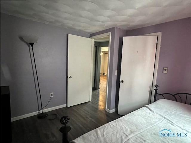 unfurnished bedroom with dark hardwood / wood-style flooring