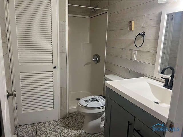 bathroom featuring tile patterned floors, toilet, a shower, wood walls, and vanity