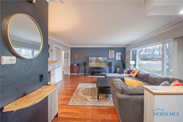 living room featuring hardwood / wood-style flooring, ornamental molding, and built in shelves