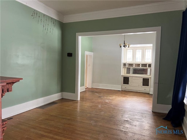 unfurnished living room with an inviting chandelier, ornamental molding, and wood-type flooring