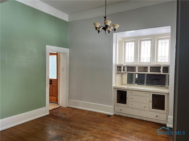 interior space featuring crown molding, dark wood-type flooring, and a chandelier