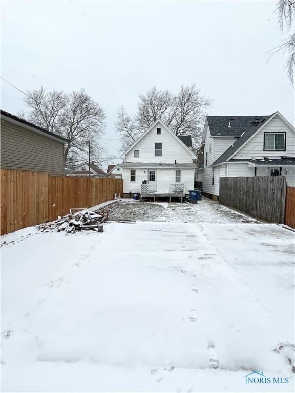 view of snow covered back of property