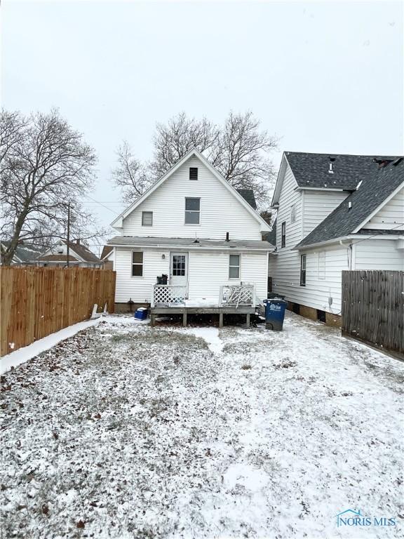 snow covered house featuring a wooden deck