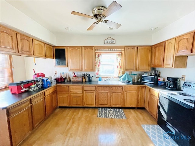 kitchen with sink, range with electric stovetop, light hardwood / wood-style flooring, and kitchen peninsula