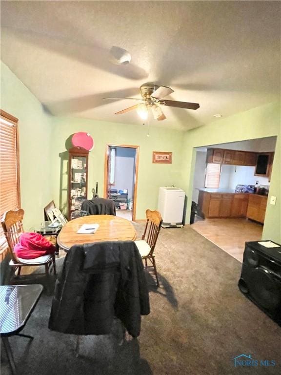 carpeted dining area featuring ceiling fan