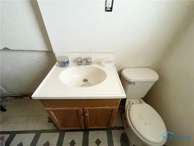 bathroom featuring vanity, toilet, and tile patterned flooring