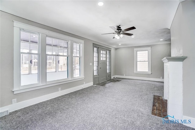 unfurnished living room featuring carpet flooring and ceiling fan