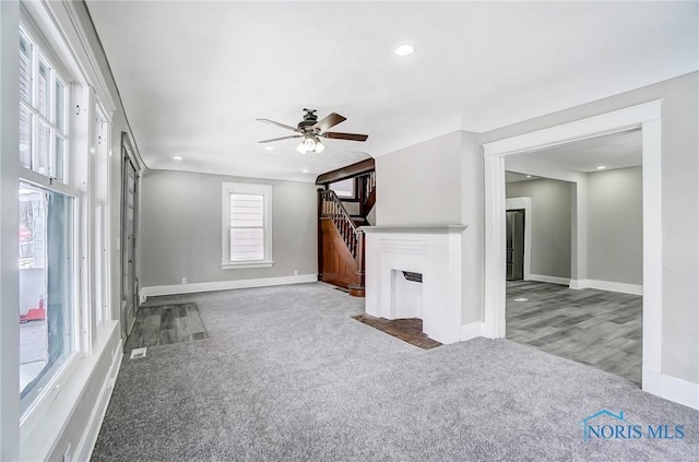 unfurnished living room with ceiling fan and light carpet