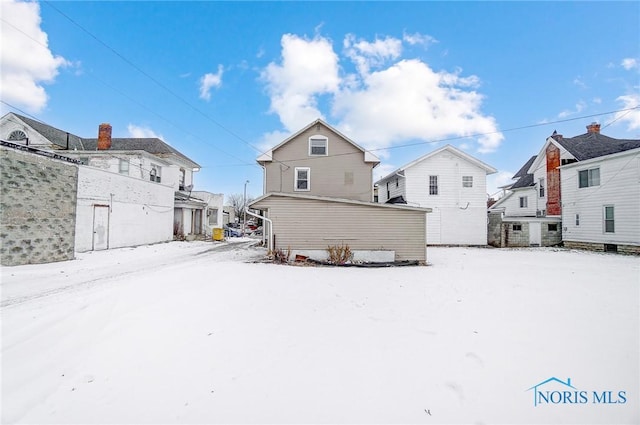 view of snow covered back of property