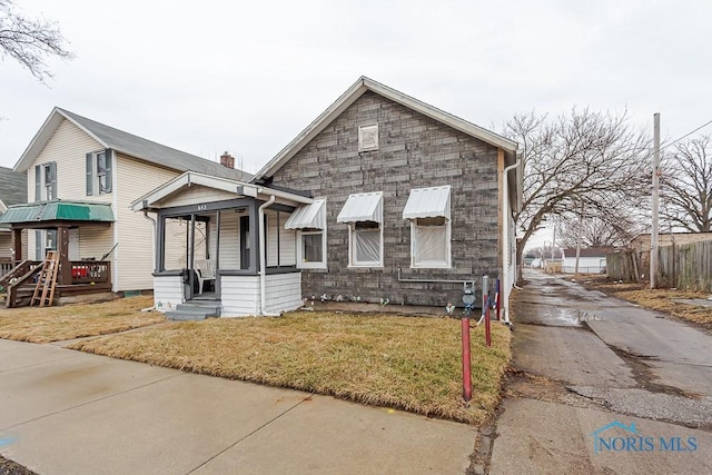 view of front of property featuring stone siding and a front lawn