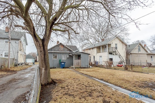 bungalow featuring an outbuilding, fence, and a residential view