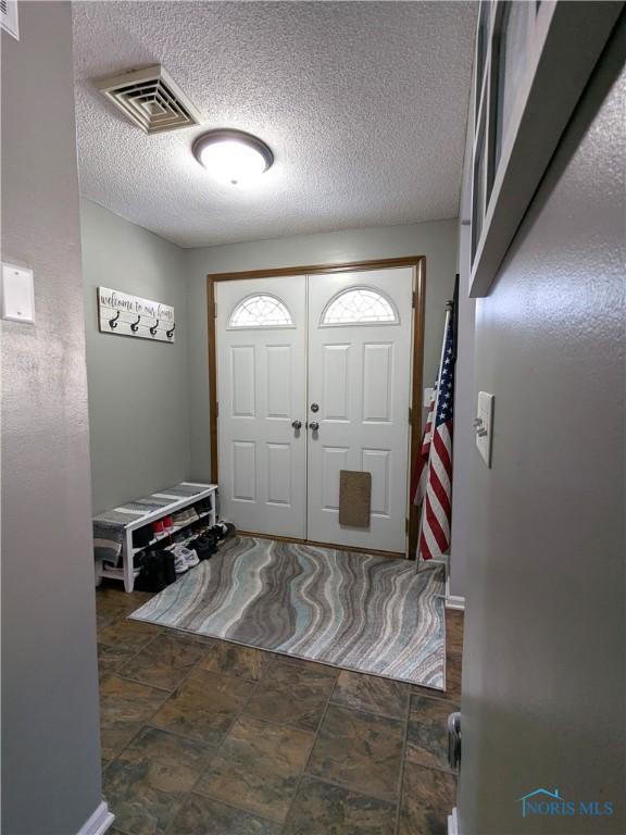 entrance foyer with a textured ceiling