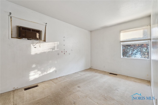 carpeted spare room with a wall unit AC