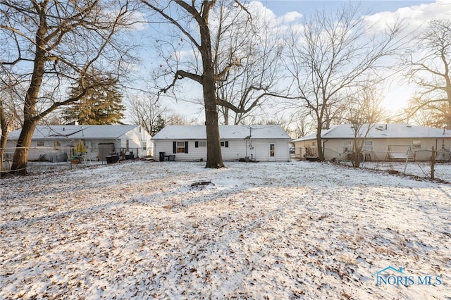 view of snow covered back of property