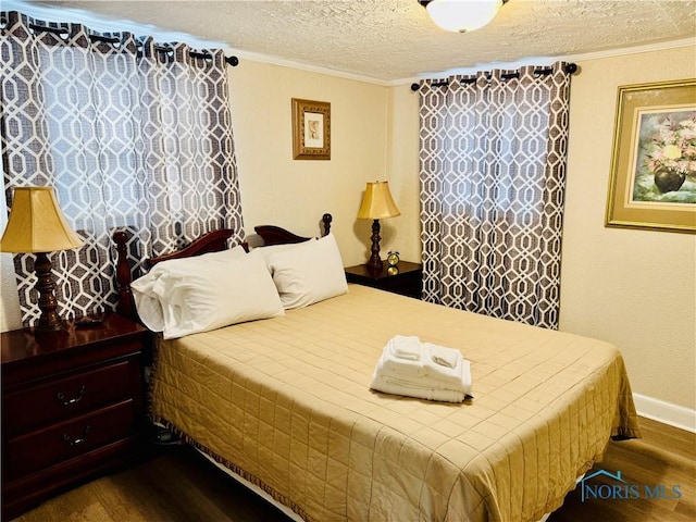 bedroom with ornamental molding, hardwood / wood-style floors, and a textured ceiling