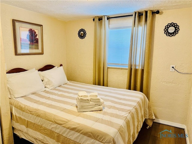 bedroom featuring wood-type flooring and a textured ceiling