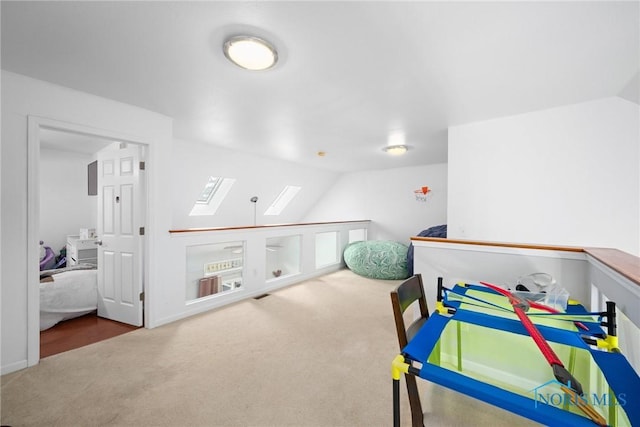 bedroom with lofted ceiling with skylight and carpet floors