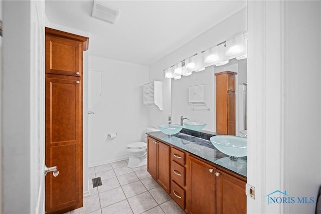 bathroom featuring vanity, tile patterned floors, and toilet