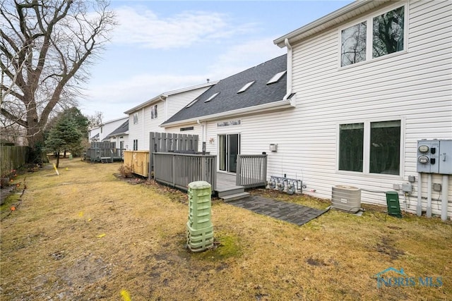 rear view of house featuring a yard, central AC, and a deck