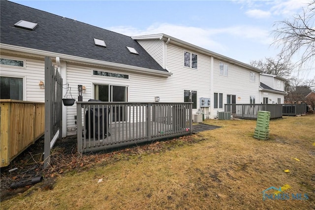 rear view of property featuring a yard, a deck, and central air condition unit