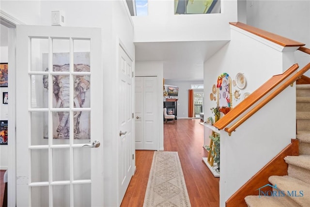 entryway with a towering ceiling and light hardwood / wood-style flooring