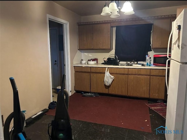 kitchen with white fridge, sink, a chandelier, and decorative light fixtures