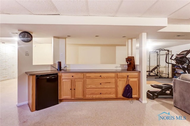 kitchen with black dishwasher, a paneled ceiling, and light colored carpet