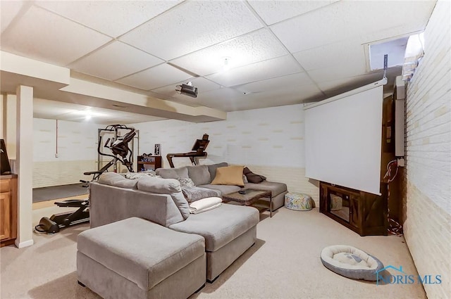 living room with light colored carpet, brick wall, and a drop ceiling